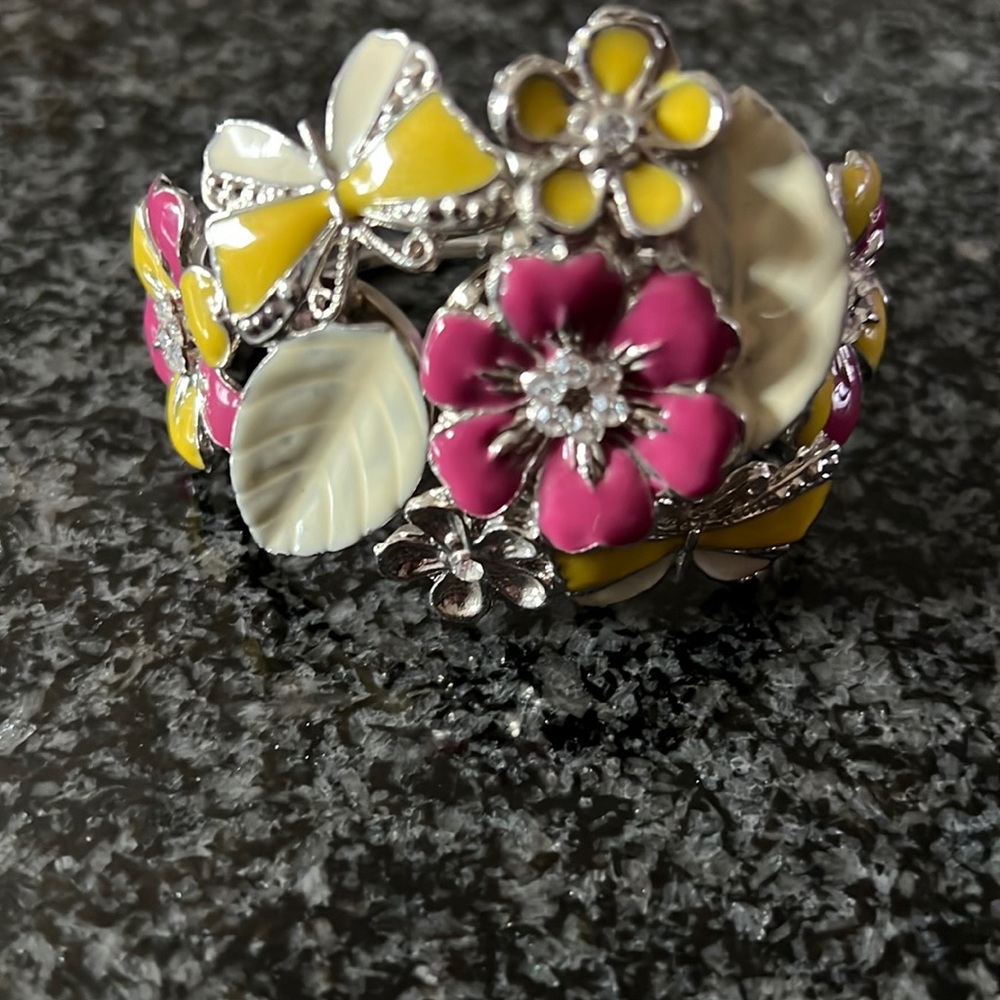 Enamel flowers metal bracelet that spring opens on top.